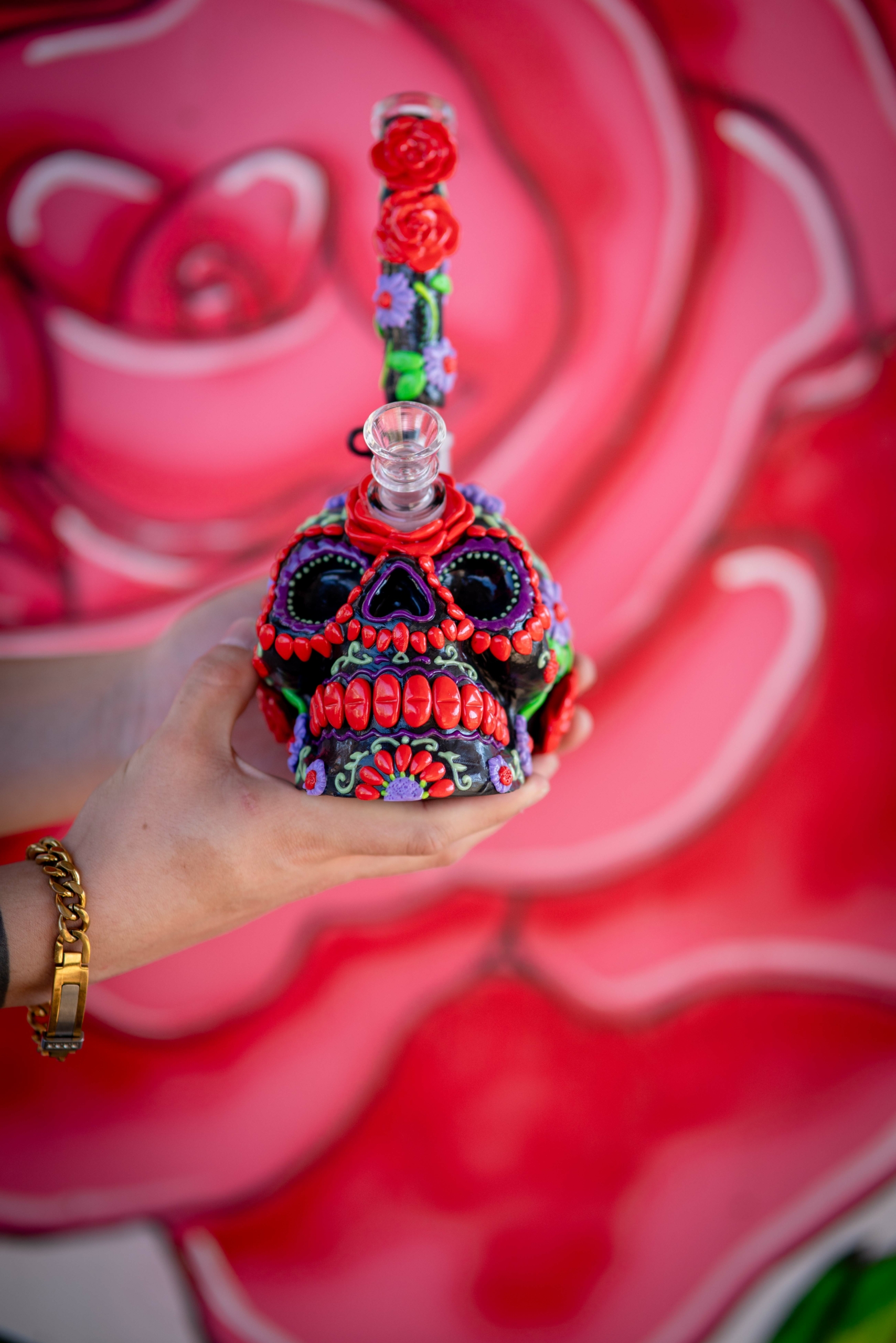 a sugar skull inspired water pipe it is red with the stem in the center of the skull