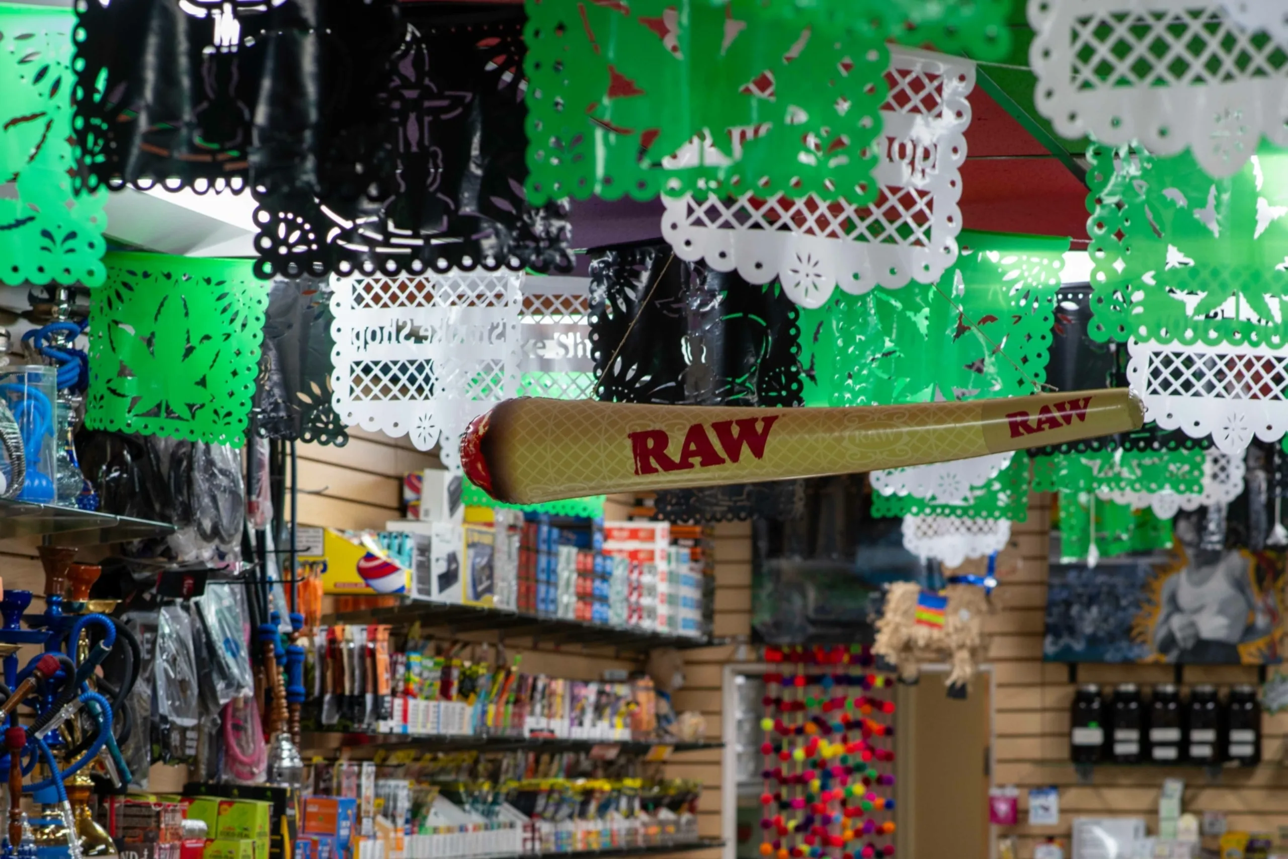 Papel picado decorations and RAW joints displayed at Fox Plaza Smoke Shop.